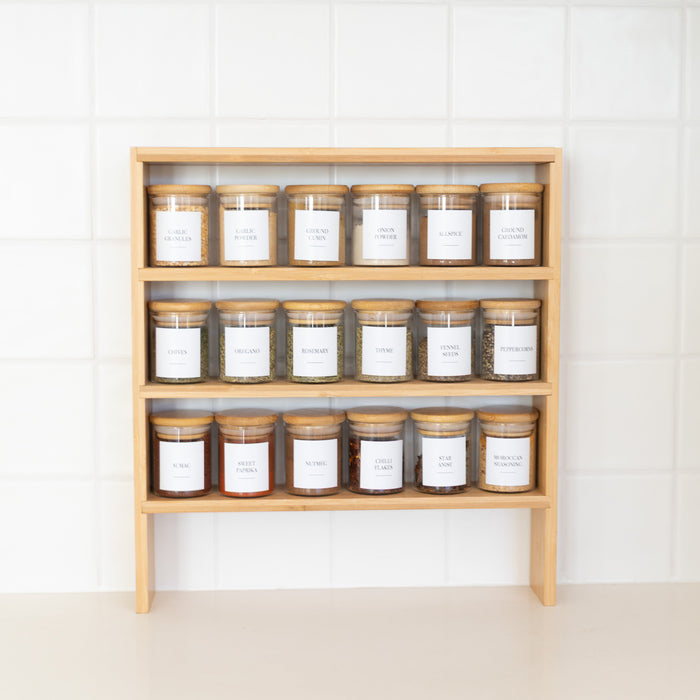 Wooden shelf with various jars on a white wall background