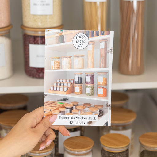 Person holding a product packaging with jars labeled in the background
